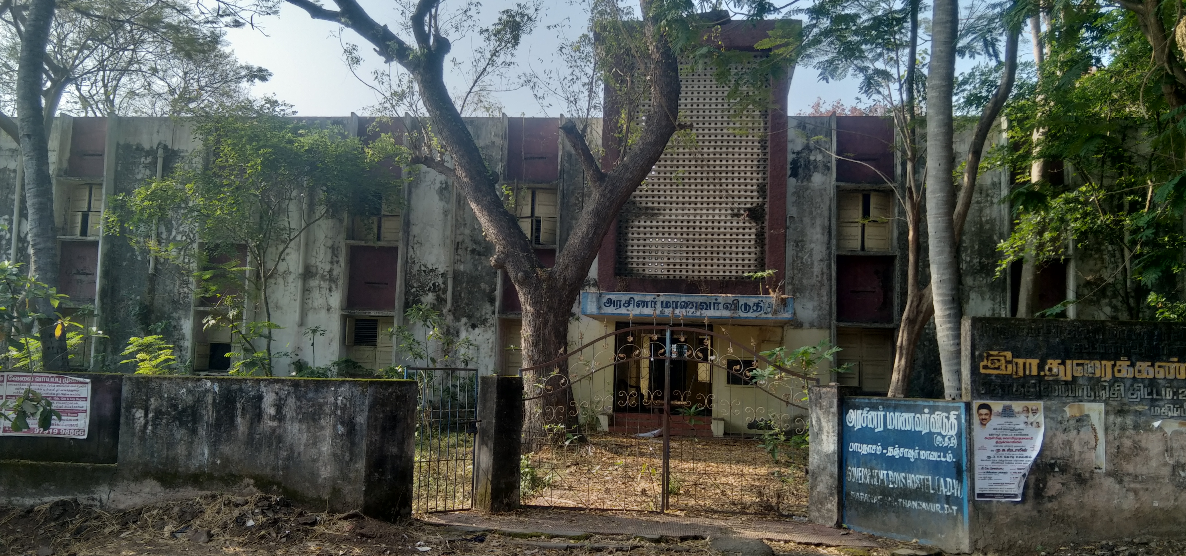 புதர் மண்டிக் கிடக்கும் அரசு மாணவர் விடுதி கட்டடம்